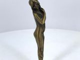 a bronze figurine of a woman holding her head in her hands
