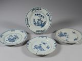 quatre assiettes bleues et blanches ornées de fleurs, posées sur une table