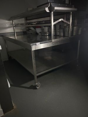 une grande table en acier inoxydable au milieu d'une cuisine