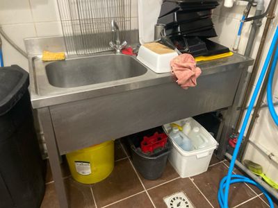 un évier de cuisine avec beaucoup de déchets par terre