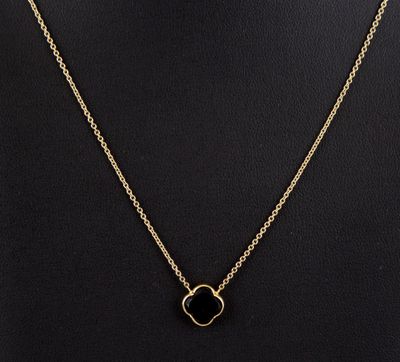 un collier en or avec un pendentif en pierre noire autour du cou d'un mannequin