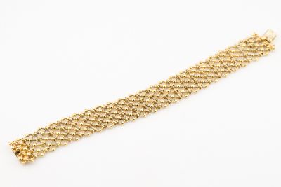 a close up of a gold chain bracelet on a white background