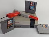 une console Nintendo avec un pistolet Nintendo et un jeu Nintendo NES