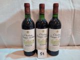 trois bouteilles de vin posées sur une nappe blanche