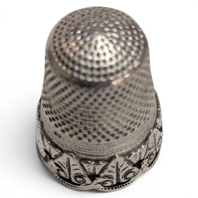 a thimble that is sitting on a white surface