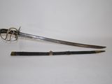 an old sword with a wooden handle sitting on top of a white surface