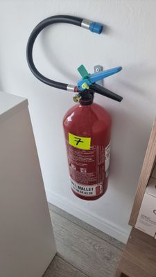 un extincteur fixé au mur d'une pièce