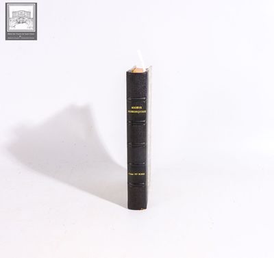 a black book with a pencil sticking out of it on a white surface