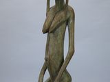 statue d'une femme assise sur un tabouret, la main posée sur le menton