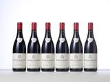 six bottles of red wine lined up in a row