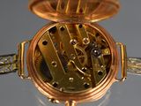 a close up of a gold pocket watch on a table