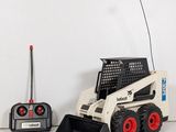 a toy ski - loader and remote control system on a table
