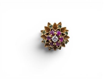 un gros plan d'une bague violette et dorée posée sur une surface blanche