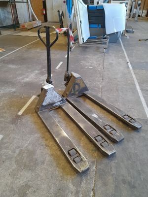 a fork lifter sitting on the floor in a warehouse