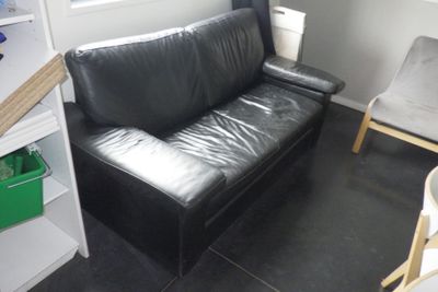 un canapé en cuir noir dans un coin de la pièce