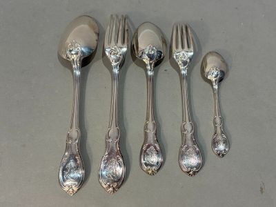 five silver spoons and a fork on a table