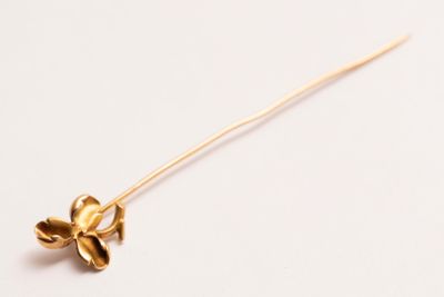 broche en forme de fleur dorée sur fond blanc