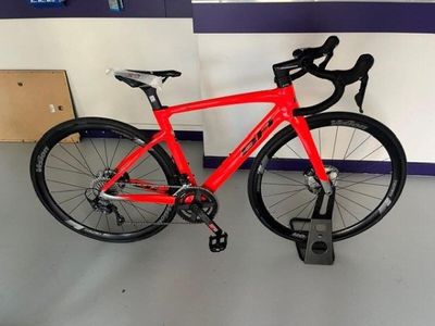 a red bike that is parked in a room