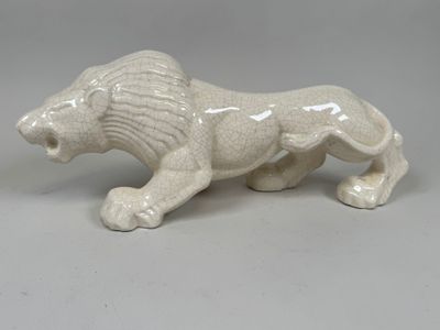 une figurine de lion blanc posée sur une table
