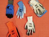 cinq paires de gants de jardinage posées sur un lit, à côté d'une paire de gants