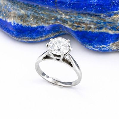 un gros plan d'une bague en diamant posée sur un caillou