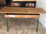 a wooden desk with two wooden chairs in front of it
