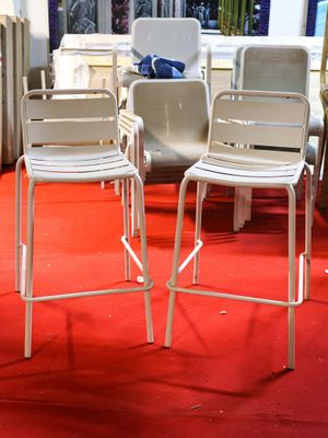 two white chairs sitting on a red carpet in a room