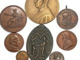 une image représentant un ensemble de pièces de monnaie et une médaille posées sur une surface blanche