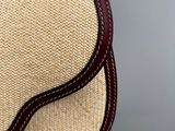 a close up of a straw bag with a brown leather strap