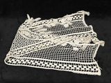 un gros plan d'un tissu blanc au crochet posé sur une surface noire