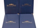 two blue books sitting on top of each other on a white surface