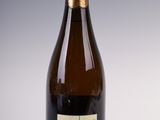 bottle of wine with a label on it sitting on a white surface