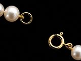 a close up of a pair of pearl earrings on a black background