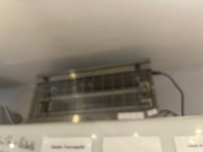 une photo d'une pièce avec un ventilateur de plafond et quelques notes accrochées au mur