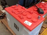 a red battery box sitting on a pallet in a warehouse