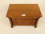 an old wooden table with three drawers and a label on the top