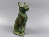 statue of a cat sitting on its hind legs on a white surface
