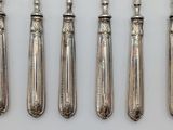 five silverware spoons and a knife on a white surface
