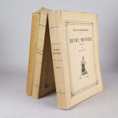 un vieux livre posé sur une table à côté d'une pile de livres