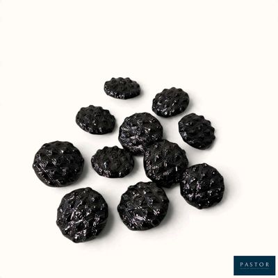 un tas de raisins secs noirs posé sur une surface blanche