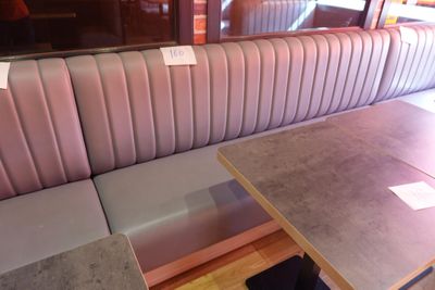 une cabine avec une table et un banc devant une fenêtre