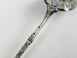 a spoon with a flower on it on a white surface