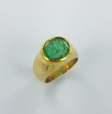 an image of a gold ring with a green stone in the center