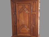 a wooden armoire with a clock on top of it