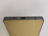 the back of a cell phone with a gold finish on it