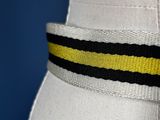 a close up of a white dress with a yellow and black striped belt