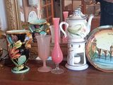 un homme en train de prendre une photo d'une collection de vases posés sur une table