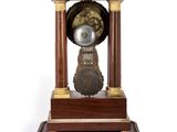 a small wooden clock on a stand on a white background