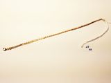 a gold chain that has been placed on a white surface