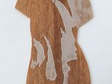 a wooden cutout of a woman ' s torso on a white surface